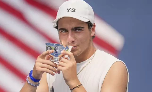 Ivan Ivanov, of Bulgaria kisses the championship trophy after defeating Alexander Vasilev, of Bulgaria, in the boys' singles final of the U.S. Open tennis championships, Saturday, Sept. 6, 2025, in New York. (AP Photo/Seth Wenig)