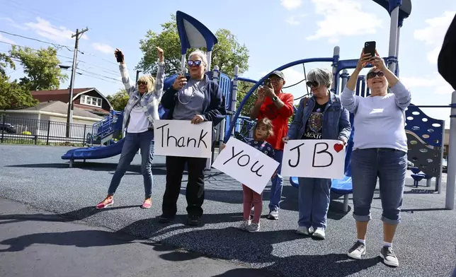 Local residents hold up signs as Gov. JB Pritzker speaks with reporters after visiting Prairie Oak Elementary School in Berwyn, Ill., Thursday, Sept. 4, 2025. (Anthony Vazquez/Chicago Sun-Times via AP, Pool)