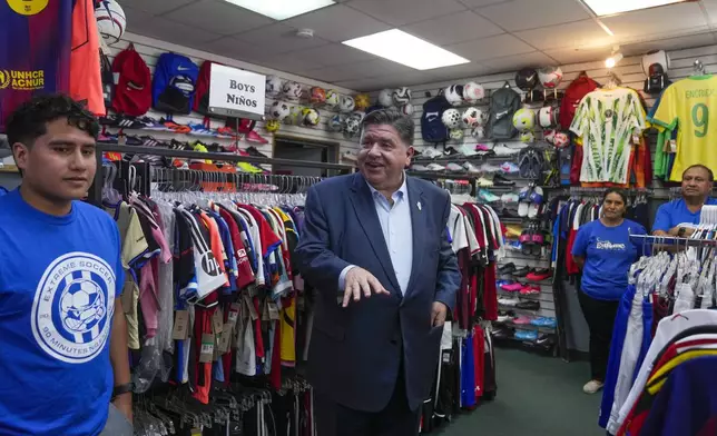 Illinois Gov. J.B. Pritzker visits with members of the family-owned soccer gear business Extreme Soccer, Thursday, Sept. 4, 2025, in Berwyn, Ill. (AP Photo/Erin Hooley)