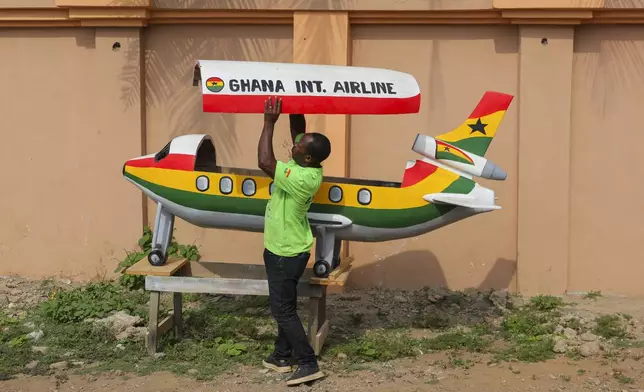 Eric Kpakpo Adotey displays an aeroplane fantasy coffin in front of his shop in La, Accra, Ghana, Friday, July 25, 2025. (AP Photo/Misper Apawu)