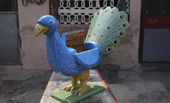 A peacock-shaped miniature fantasy coffin prototype crafted by Nicholas Ablorh Annan is displayed in his father's workshop in Teshie, Accra, Ghana, Tuesday, July 29, 2025. (AP Photo/ Misper Apawu)