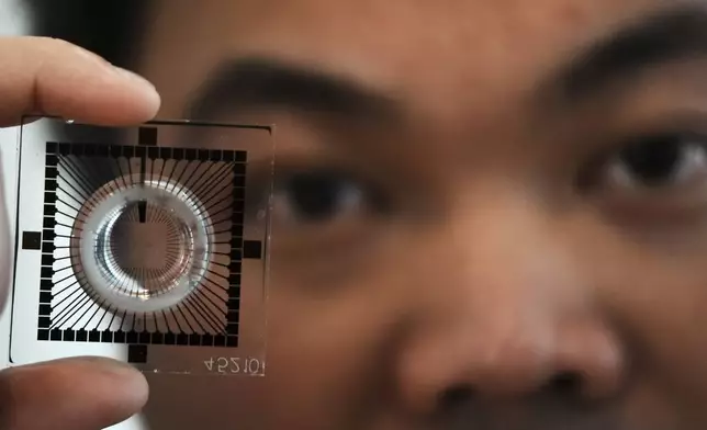 Dr Hon Weng Chong CEO of Cortical Labs showing a chip used to grow neurons into for computation and AI processing at the first International Humanoid Olympiad at the Olympic Academy, in ancient Olympia, Greece, Monday, Sept. 1, 2025. (AP Photo/Thanassis Stavrakis)