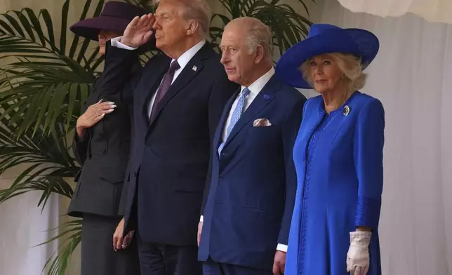 President Donald Trump salutes as he stands beside Britain's King Charles III and Queen Camilla with Melania Trump on the left during the national anthem at Windsor Castle in Windsor, England, Wednesday, Sept. 17, 2025.(AP Photo/Kirsty Wigglesworth, Pool)
