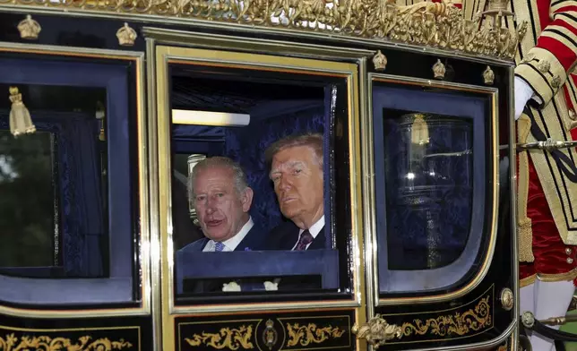 Britain's King Charles III and President Donald Trump sit in a carriage during a procession through Windsor Castle, in Windsor, England, Wednesday, Sept. 17, 2025. (Toby Melville/Pool Photo via AP)