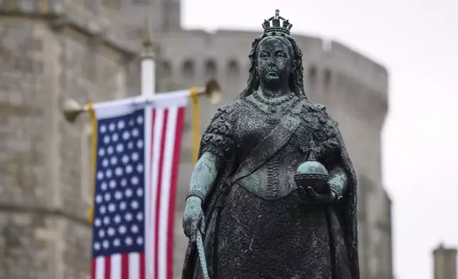 The Queen Victria Statue is seen beside the Flag of the United States of America in Windsor, England, Wednesday, Sept. 17, 2025 ahead of the arrival of President Donald Trump.(AP Photo/Alastair Grant)