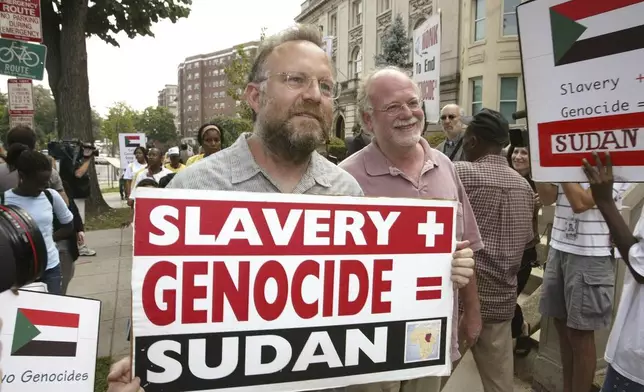 FILE - Founders of Ben &amp; Jerry's Ice Cream Jerry Greenfield , left, and Ben Cohen, pink shirt, protest in front of Sudan's embassy July 29, 2004, in Washington. (AP Photo/Charles Dharapak, File)