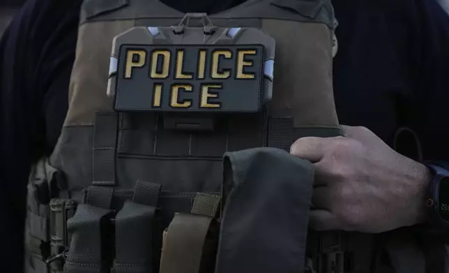 A U.S. Immigration and Customs Enforcement agent takes part in an early morning operation in Park Ridge, Ill., Friday, Sept. 19, 2025. (AP Photo/Erin Hooley)