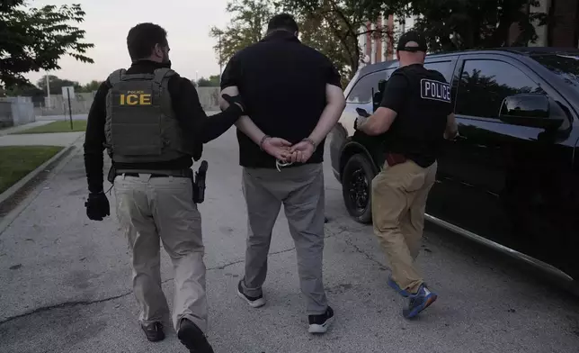 U.S. Immigration and Customs Enforcement agents make an arrest during an early morning operation in Park Ridge, Ill., Friday, Sept. 19, 2025. (AP Photo/Erin Hooley)