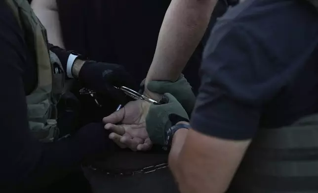 U.S. Immigration and Customs Enforcement agents make an arrest during an early morning operation in Park Ridge, Ill., Friday, Sept. 19, 2025. (AP Photo/Erin Hooley)