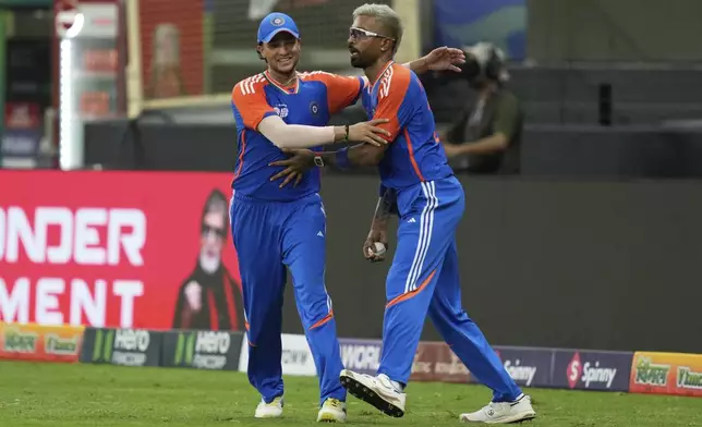 India's Hardik Pandya, right, celebrates with teammate Abhishek Sharma after taking the catch to dismiss Pakistan's Sahibzada Farhan during the Asia Cup cricket match between India and Pakistan at Dubai International Cricket Stadium in Dubai, United Arab Emirates, Sunday, Sept. 14, 2025. (AP Photo/Altaf Qadri)