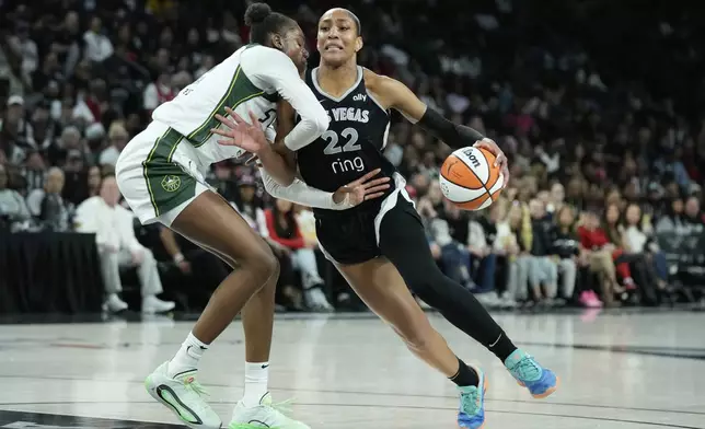 Las Vegas Aces center A'ja Wilson (22) drives against Seattle Storm center Dominique Malonga (14) during the second half of Game 3 in the first round of the WNBA basketball playoffs Thursday, Sept. 18, 2025, in Las Vegas. (AP Photo/John Locher)