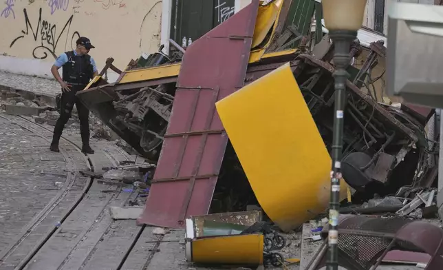 Police officers inspect the site where a tourist streetcar derailed and crashed in Lisbon, Portugal, Thursday, Sept. 4, 2025. (AP Photo/Armando Franca)