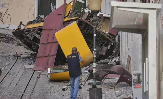 Police officers inspect the site where a tourist streetcar derailed and crashed in Lisbon, Portugal, Thursday, Sept. 4, 2025. (AP Photo/Armando Franca)