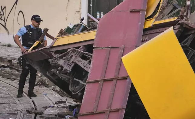 Police officers inspect the site where a tourist streetcar derailed and crashed in Lisbon, Portugal, Thursday, Sept. 4, 2025. (AP Photo/Armando Franca)