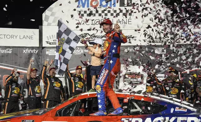 Chase Briscoe, center, celebrates with his son Brooks in Victory Lane after winning a NASCAR Cup Series auto race at Darlington Raceway, Sunday, Aug. 31, 2025, in Darlington, S.C. (AP Photo/Matt Kelley)