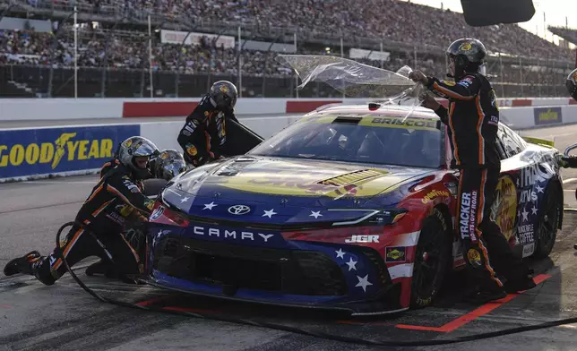 The pit crew for Chase Briscoe rushes to complete a pit stop during a NASCAR Cup Series auto race at Darlington Raceway, Sunday, Aug. 31, 2025, in Darlington, S.C. (AP Photo/Matt Kelley)