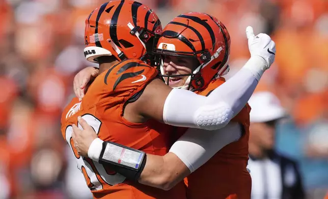 Cincinnati Bengals quarterback Jake Browning, right, is hugged by tight end Noah Fant after Browning's rushing touchdown during the second half of an NFL football game against the Jacksonville Jaguars, Sunday, Sept. 14, 2025, in Cincinnati. (AP Photo/Jeff Dean)