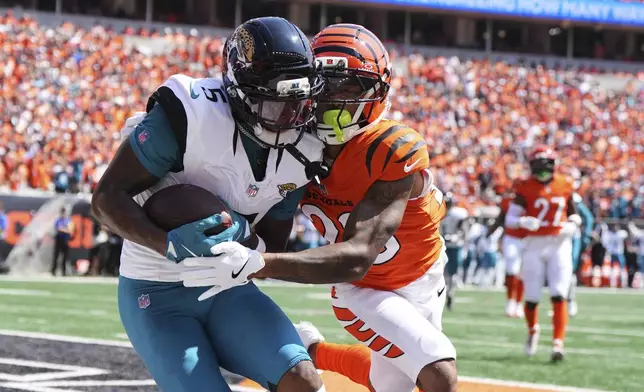 Jacksonville Jaguars wide receiver Dyami Brown (5) catches a touchdown past Cincinnati Bengals cornerback DJ Turner II during the first half of an NFL football game, Sunday, Sept. 14, 2025, in Cincinnati. (AP Photo/Jeff Dean)