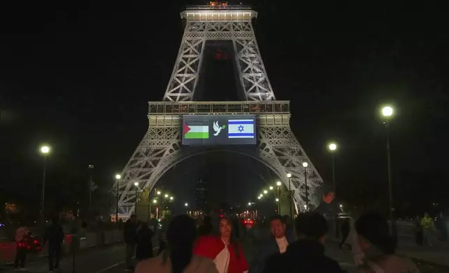 A large screen displays Palestinian and Israeli flags and a dove on the Eiffel Tower, Sunday, Sept. 21, 2025 in Paris, as France prepares to formally recognize a Palestinian state at the United Nations General Assembly. (AP Photo/Christophe Ena)