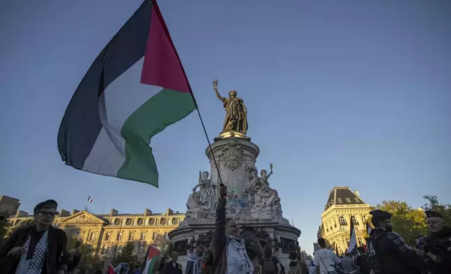 A woman holds a Palestinian flag during a pro-Palestinian gathering at Republic square in Paris, Wednesday, Sep. 17, 2025. (AP Photo/Aurelien Morissard)
