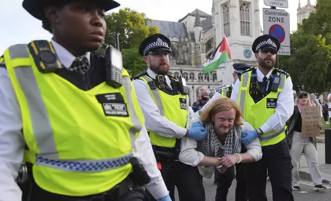 Police officers carry a protester during a protest to support Palestine Action in London, Saturday, Sept. 6, 2025.(AP Photo/Joanna Chan)