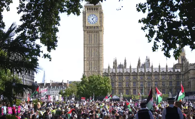Prortesters in Parliament Square are watched by police during a protest to support Palestine Action in London, Saturday, Sept. 6, 2025.(AP Photo/Joanna Chan)