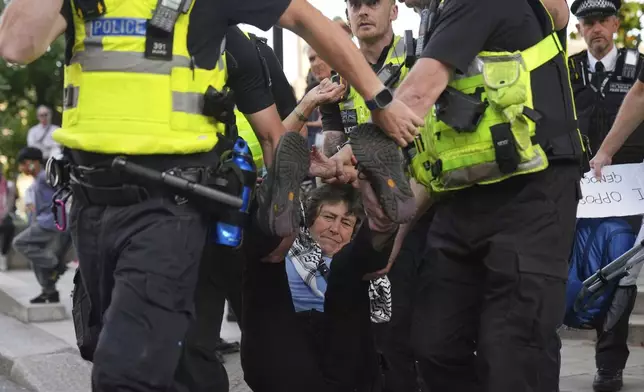 Police officers carry a protester during a protest to support Palestine Action in London, Saturday, Sept. 6, 2025.(AP Photo/Joanna Chan)