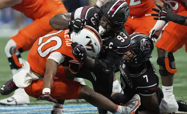 South Carolina defensive lineman Nick Barrett (93) tackles Virginia Tech running back P.J. Prioleau (20) during an NCAA college football game, Sunday, Aug. 31, 2025, in Atlanta. (AP Photo/Brynn Anderson)