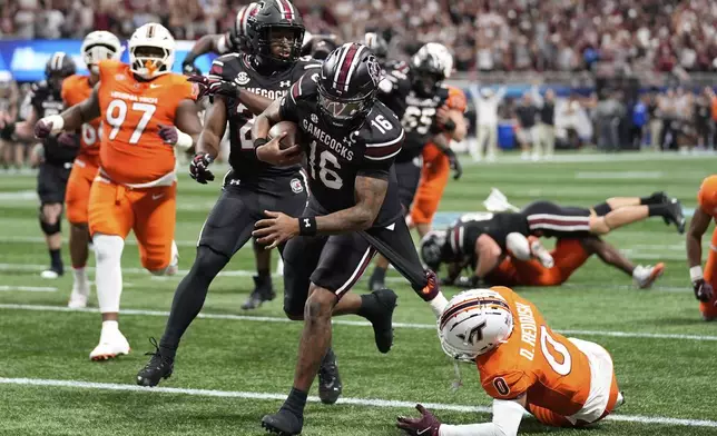South Carolina quarterback LaNorris Sellers (16) scores against Virginia Tech safety Quentin Reddish (0) during an NCAA college football game, Sunday, Aug. 31, 2025, in Atlanta. (AP Photo/Brynn Anderson)
