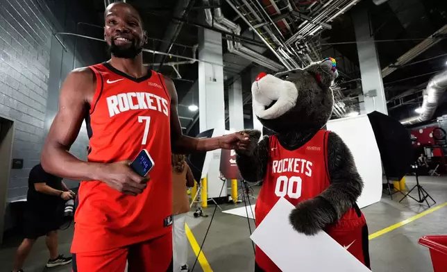 Houston Rockets forward Kevin Durant (7) jokes greets mascot Clutch during the NBA basketball team's media day in Houston, Monday, Sept. 29, 2025. (AP Photo/Ashley Landis)