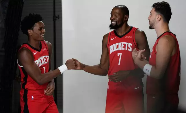 Houston Rockets forward Amen Thompson (1) greets forward Kevin Durant (7) and center Alperen Sengun (28) during the NBA basketball team's media day in Houston, Monday, Sept. 29, 2025. (AP Photo/Ashley Landis)