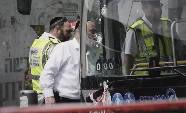 Israeli police and rescue teams inspect the scene of a shooting attack carried out by two Palestinian gunmen, in which several people were killed and others injured at a bus stop in Jerusalem, Monday, Sept. 8, 2025. (AP Photo/Mahmoud Illean)