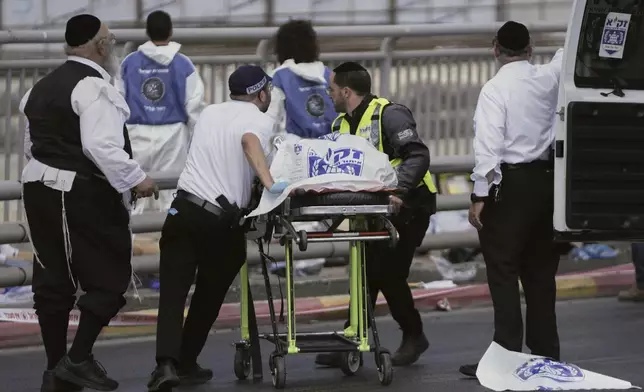 Israeli Zaka rescue and recovery team carry the body of a victim at the scene of shooting attack carried out by two Palestinian gunmen, in which several people were killed and others injured at a bus stop in Jerusalem, Monday, Sept. 8, 2025. (AP Photo/Mahmoud Illean)