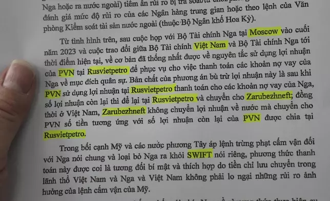 An AP reporter displays an excerpt from a June 11, 2024 memo from Vietnam's Oil and Gas Group (PVN) to the Ministry of Industry and Trade detailing an arrangement to avoid potential American sanctions when purchasing Russian defense goods, in Bangkok, Thailand, on Sept. 16, 2025. (AP Photo/Sakchai Lalit)
