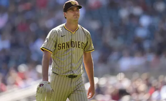San Diego Padres relief pitcher Kyle Hart walks back to the dugout after completing the bottom of the third inning of a baseball game against the Minnesota Twins, Sunday, Aug. 31, 2025, in Minneapolis. (AP Photo/Abbie Parr)