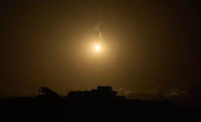 An Israeli army flare drifts over buildings destroyed during Israeli ground and air operations in the northern Gaza Strip, as seen from southern Israel, Thursday, Sept. 25, 2025. (AP Photo/Leo Correa)