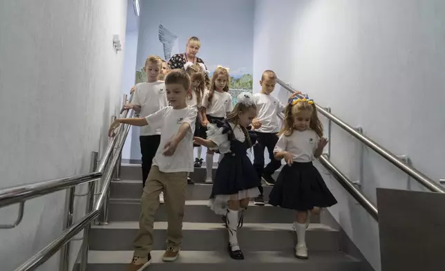 Schoolchildren enter an underground school on the first day at school in Kharkiv, Ukraine, Monday, Sept. 1, 2025. (AP Photo/Andrii Marienko)
