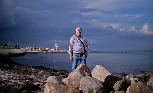 Axel Kramer a tourist guide and amber expert poses for a photo during a guided amber hunt for tourists on the beach of the Baltic resort of Dahme, Germany, Tuesday, Sept. 2, 2025. (AP Photo/Markus Schreiber)