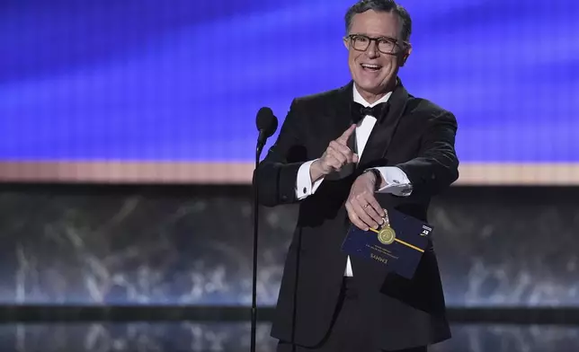 Stephen Colbert presents the award for outstanding lead actor in a comedy series during the 77th Primetime Emmy Awards on Sunday, Sept. 14, 2025, at the Peacock Theater in Los Angeles. (AP Photo/Chris Pizzello)