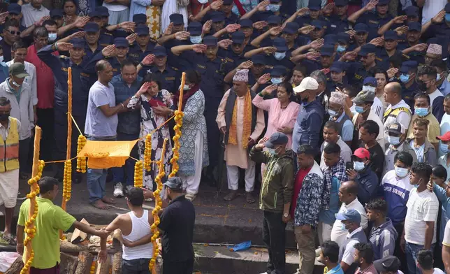 Mourners pay their last respects to Assistant Sub-Inspector officer Milan Raya, who was killed during anti-corruption protests that erupted after a social media ban was later revoked is prepared for cremation at Pashupatinath in Kathmandu, Nepal, Friday, Sept. 12, 2025. (AP Photo/Niranjan Shrestha)