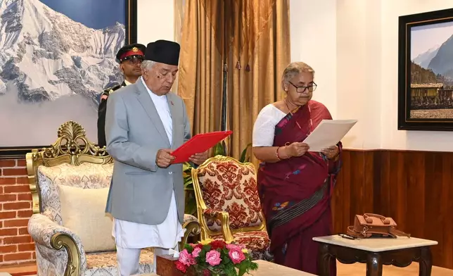 In this photo provided by the Nepalese President House, former Supreme Court Chief Justice Sushila Karki, right, is administered the oath of office by Nepalese President Ram Chandra Poudel, center, in Kathmandu, Nepal, Friday, Sept. 12, 2025, following protests that collapsed the previous administration. (Nepalese President House via AP)