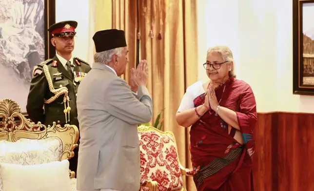 Former Supreme Court Chief Justice Sushila Karki, right, greets Nepalese President Ram Chandra Poudel after taking the oath as interim prime minister during a ceremony at the presidential residence in Kathmandu, Nepal, Friday, Sept. 12, 2025. (AP Photo/Sujan Gurung)