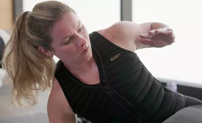 CORRECTS YEAR TO 2025, NOT 2024 - Nora Capocci wears a weighted vest during an MB360 workout class at the Life Time health club in New York on Wednesday, Aug. 13, 2025. (AP Photo/Shelby Lum)