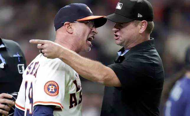 After being ejected from the game, Houston Astros manager Joe Espada, left, argues with third base umpire Mike Muchlinski during the sixth inning of a baseball game against the Seattle Mariners, Saturday, Sept. 20, 2025, in Houston. (AP Photo/Eric Christian Smith)