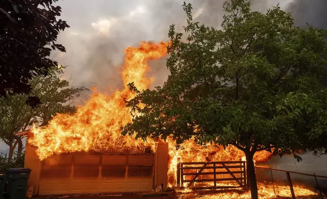 Flames consume a garage as the 6-5 Fire burns through the Chinese Camp community of Tuolumne County, Calif., on Tuesday, Sept. 2, 2025. (AP Photo/Noah Berger)