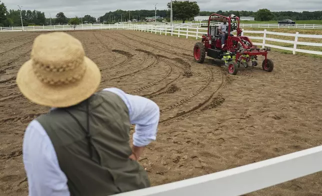 MK Bashar, right, test drives an electric tractor as Ben Phillips, left, watches Tuesday, Aug. 19, 2025, during a demonstration in East Lansing, Mich. (AP Photo/Joshua A. Bickel)