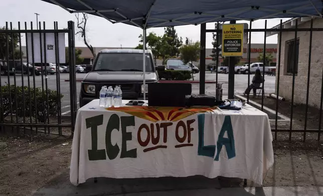 A table covered with a cloth reading "ICE Out of LA" sits under a canopy next to the job center for day laborers outside a Home Depot in the Van Nuys section of Los Angeles, Aug. 28, 2025. (AP Photo/Jae C. Hong)