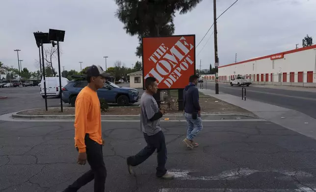Workers walk toward a food vendor past a Home Depot sign in the Van Nuys section of Los Angeles, Aug. 28, 2025. (AP Photo/Jae C. Hong)