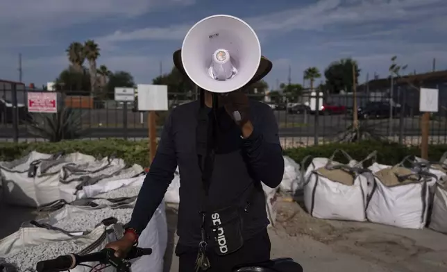 Luis poses with a megaphone used to alert other day laborers of ICE operations in the parking lot of a Home Depot in the Van Nuys section of Los Angeles, Aug. 28, 2025. (AP Photo/Jae C. Hong)