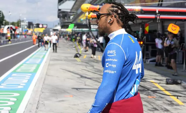 Ferrari driver Lewis Hamilton of Britain walks through the pits before the first free practice ahead of the Italian Grand Prix at the Monza racetrack in Monza, Italy, Friday, Sept. 5, 2025. (AP Photo/Luca Bruno)